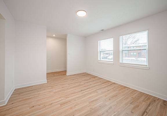 Empty room with wooden floor and white walls.
