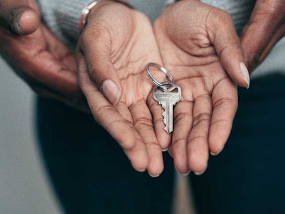 Two hands holding a key.