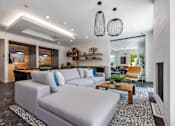 Thumbnail 6 of 8 - A modern living room with a grey sofa and a wooden coffee table.