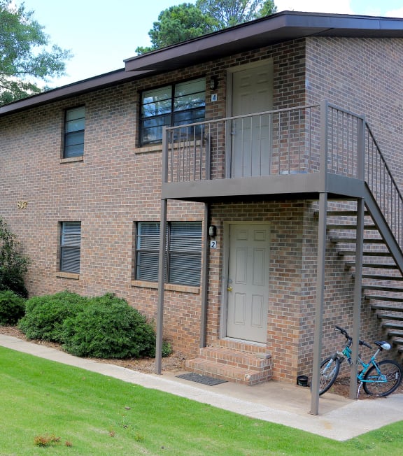 the front of a brick apartment building with a bike parked outside