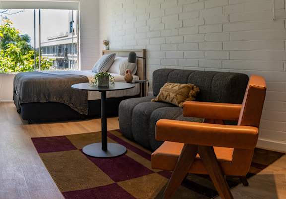 a living room with a couch and a table in front of a bed