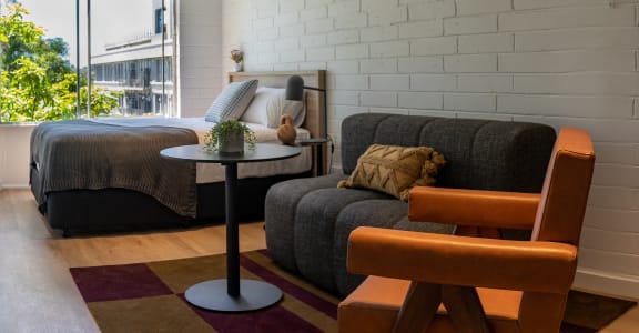 a living room with a couch and a table in front of a bed