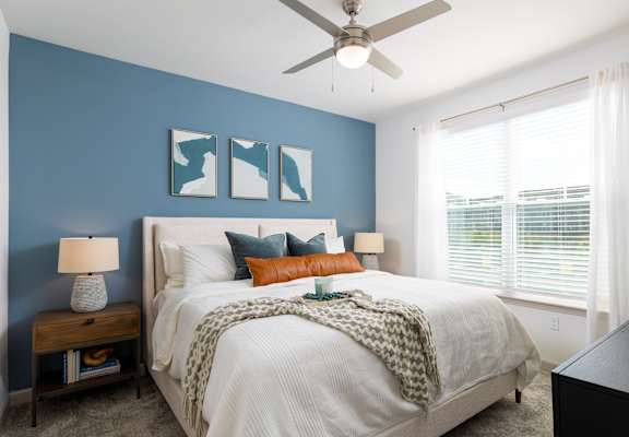 a bedroom with a large bed and a ceiling fan