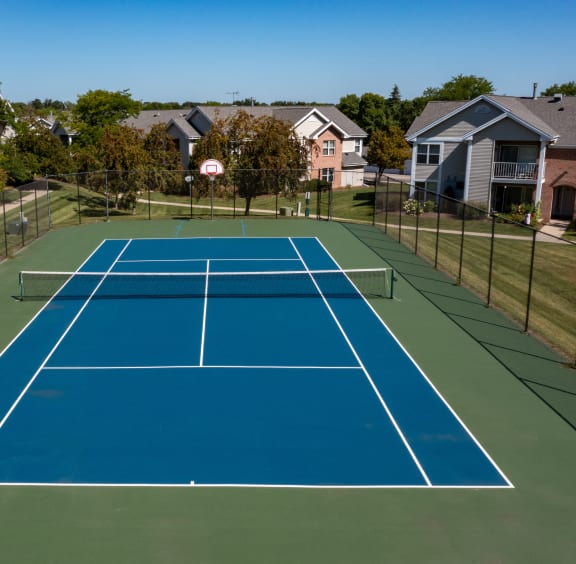 a tennis court with a house in the background