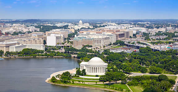 An aerial view of a city with a large white dome building in the center.