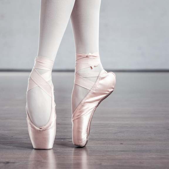 a close up of a ballet dancer in ballet shoes