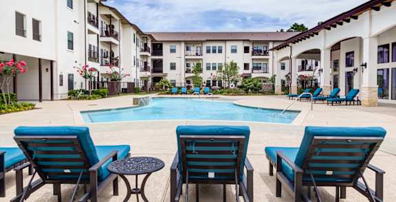 Pool along with chairs at The Laurel at Vintage Park 55+ Apartments, Tomball