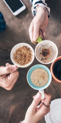 a group of people sitting around a table drinking coffee