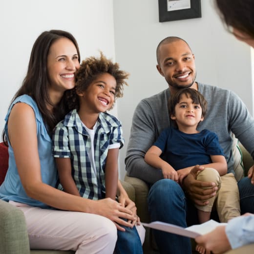 a family sitting on a couch and smiling at the camera