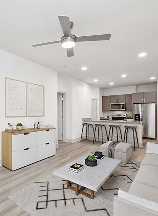Model Living Room with Wood-Style Flooring and View of Kitchen at Alta 3Eighty Apartments located in Aubrey, TX-WELCOME.