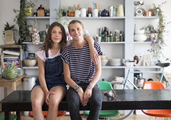 a man and a woman sitting on a table in a living room