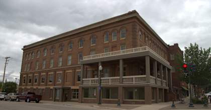 A large brown building with a balcony on the second floor.