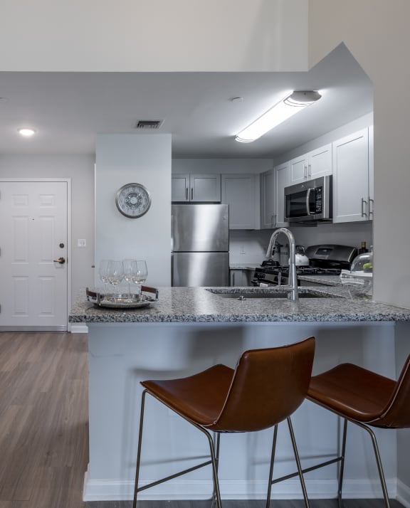 a kitchen with a marble counter top and two stools