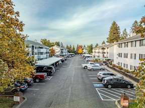 A parking lot with cars and trees in the background.at Ironwood Apartments, Coeur d'Alene, Idaho