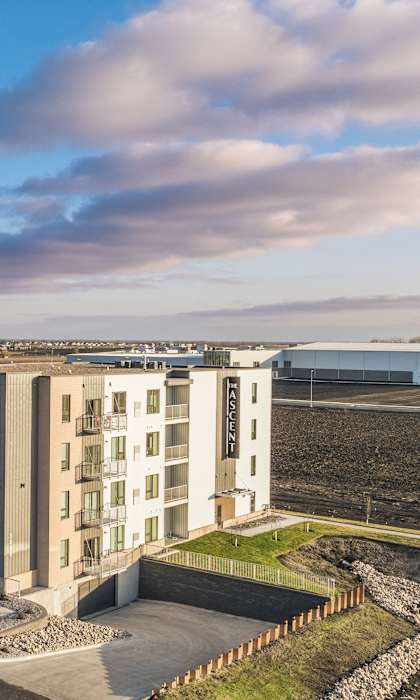 an aerial view of an apartment building with cars parked in front of it