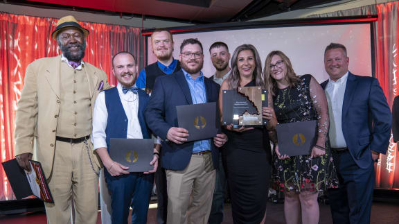 a group of people standing next to each other holding awards