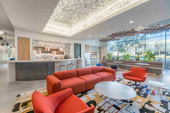 A modern office lobby with a reception desk and a large window.
