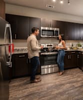 A modern kitchen with a large island and a dining table set for four.