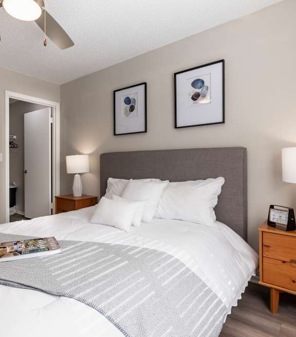 A bedroom with a large bed and a ceiling fan.