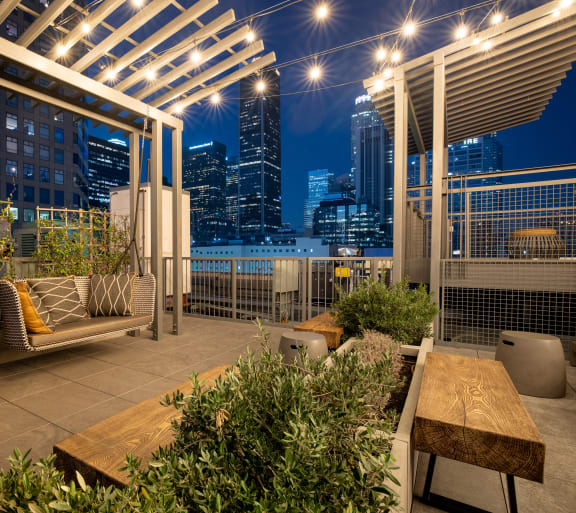 Rooftop patio with lounge furniture and lights at South Park Lofts, Los Angeles, CA