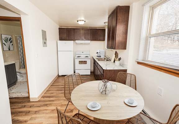 A kitchen with a table and chairs in the middle of the room.
