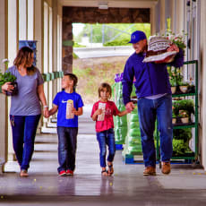 a family walks down a corridor with groceries in their hands