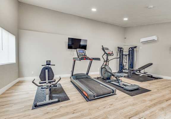 A spacious home gym with a variety of exercise equipment.