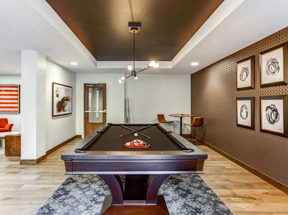 A pool table in a room with a red chair and an American flag.