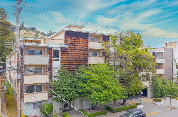a view of an apartment building with cars parked on the street