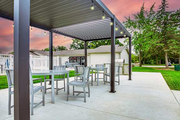 A patio with a table and chairs under a roof.