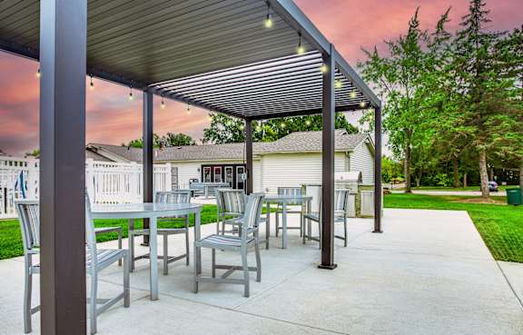 A patio with a table and chairs under a roof.
