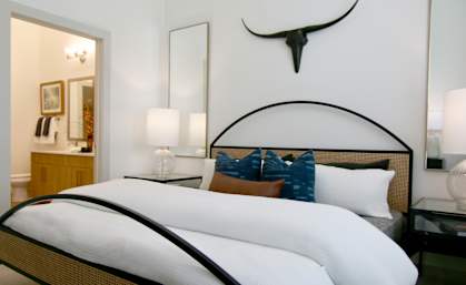 a bedroom with a large bed and a skull on the wall above it