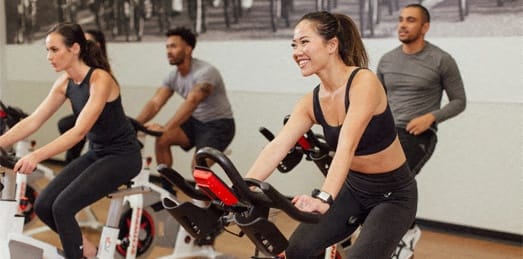 a group of people cycling on an exercise bike in a gym at Market Square Place, Pittsburgh, PA, 15222