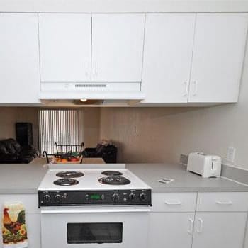 a white kitchen with a white stove and white cabinets at Oak Chase II, Tampa, 33612
