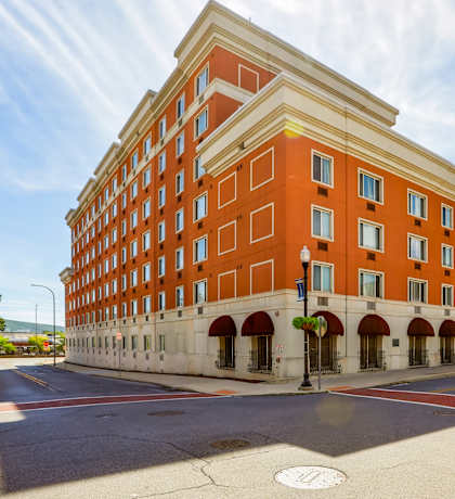 A red brick building with a white trim and arched windows.