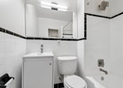 Thumbnail 42 of 59 - A white toilet sits next to a sink in a bathroom.