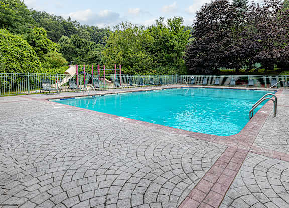 A large outdoor swimming pool surrounded by trees.