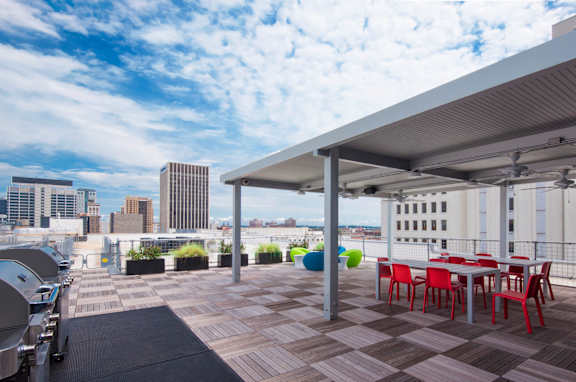 a rooftop patio with tables and chairs and a city in the background at 20 Midtown, Birmingham, 35233