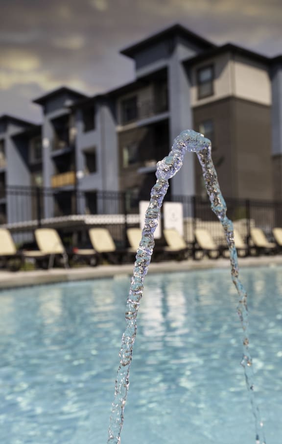 a pool with a faucet in front of a building