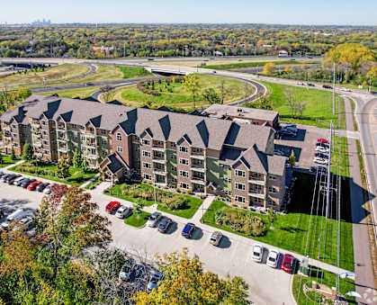 A large apartment complex with a parking lot in front.
