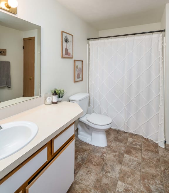 a bathroom with a white sink and toilet next to a white shower curtain  at Ironwood Apartments, Coeur d'Alene, 83814