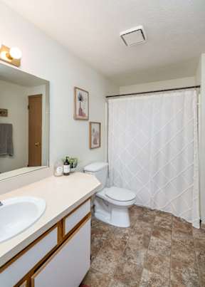 A white toilet sits next to a sink in a bathroom. at Ironwood Apartments, Coeur dAlene