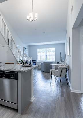 an open kitchen and living room with a staircase