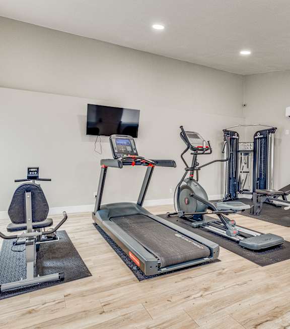 A spacious home gym with a variety of exercise equipment.