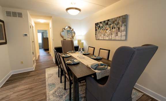 A dining room with a table set for four.