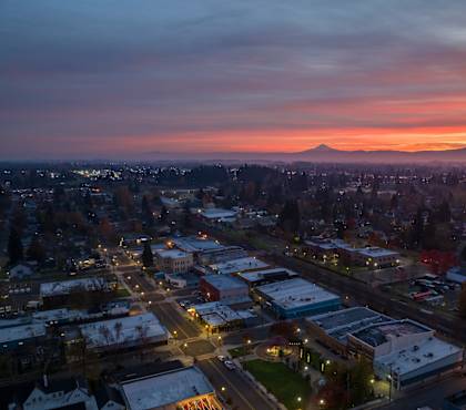 A cityscape at dusk with a mountain in the distance.