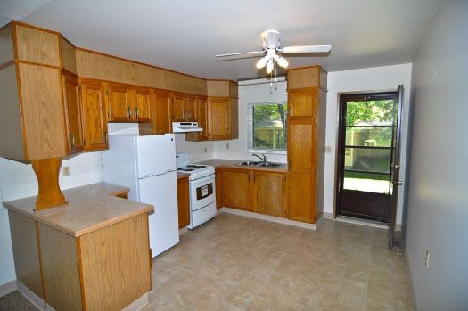 a kitchen with a white refrigerator freezer next to a stove top oven