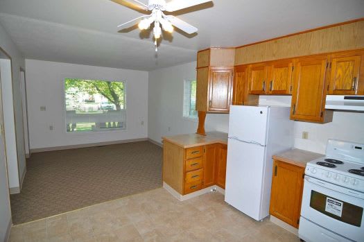 a kitchen with a stove a refrigerator and a ceiling fan