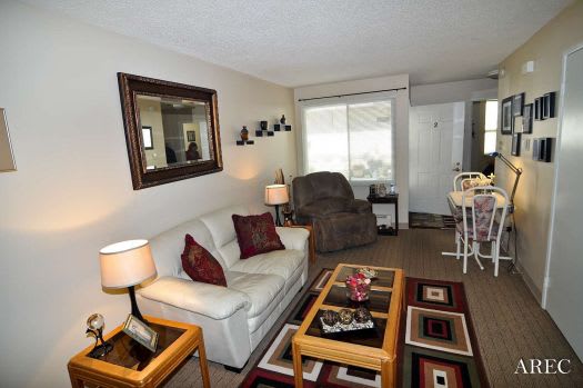 a living room filled with furniture and a large mirror