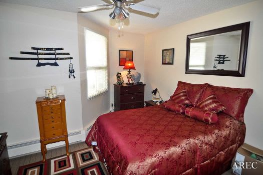a bedroom with a bed and a ceiling fan